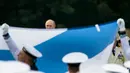 Presiden Putin (tengah) memperhatikan para pelaut mengibarkan bendera Angkatan Laut Nasional Rusia saat perayaan di St.Petersburg, Rusia, Minggu (30/7). Sedangkan Hari Angkatan Laut dibentuk di Uni Soviet pada 24 Juli 1939. (AP/Alexander Zemlianichenko)