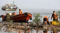 Petugas mengunakan perahu mengangkut sampah di pesisir Muara Angke, Jakarta, Kamis (29/10). Setiap harinya mereka yang digaji UMR berkeliling membersihkan sampah yang terbawa arus laut maupun aliran sungai Kanal Banjir Barat. (Liputan6.com/Faizal Fanani)