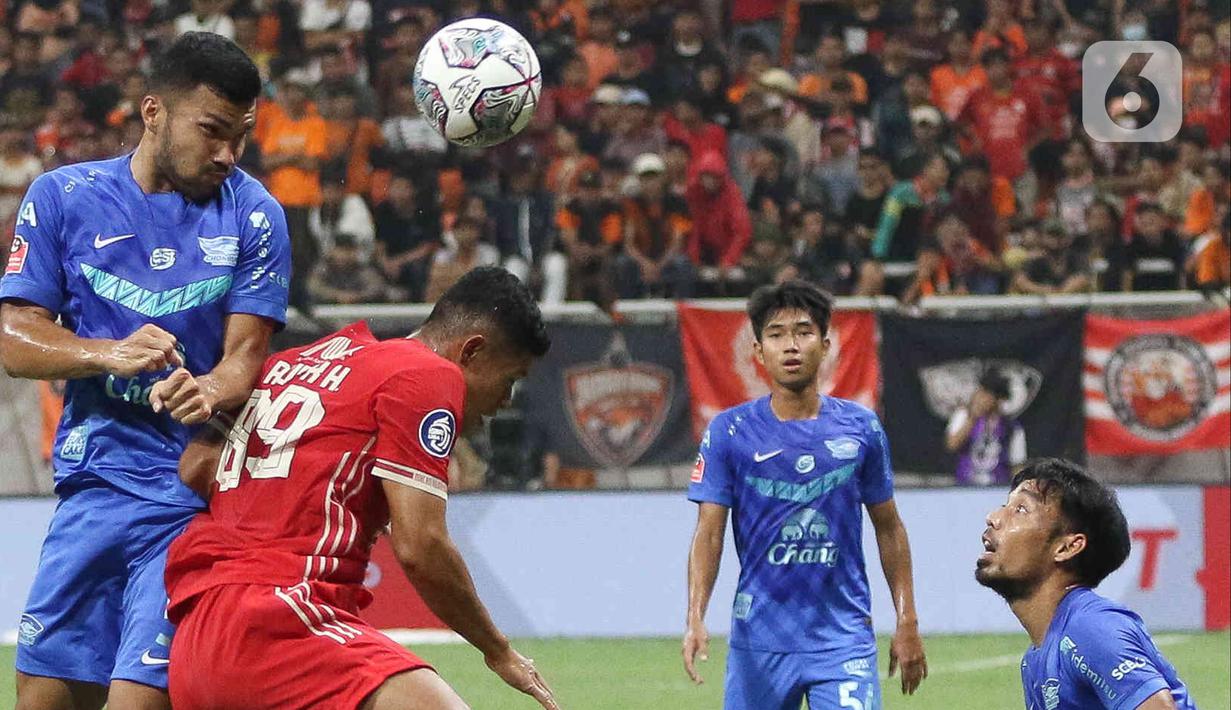 Pesepak bola Persija Jakarta Taufik Hidayat merebut bola dari pesepak bola Chonburi FC pada laga persahabatan dalam rangka peresmian Stadion Jakarta International Stadium (JIS) di Jakarta, Minggu (24/7/2022). Pertandingan berakhir imbang dengan skor 3-3. (Liputan6.com/Herman Zakharia)