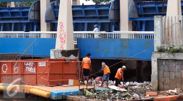 Petugas dari Dinas Kebersihan mengangkut sampah yang tersangkut di Pintu Air, Jakarta, Jum'at (30/9). Perawatan Pintu Air dari tumpukan sampah yang tersangkut agar buka tutup pintu air Jembatan Hanging dapat maksimal. (Liputan6.com/Johan Tallo)