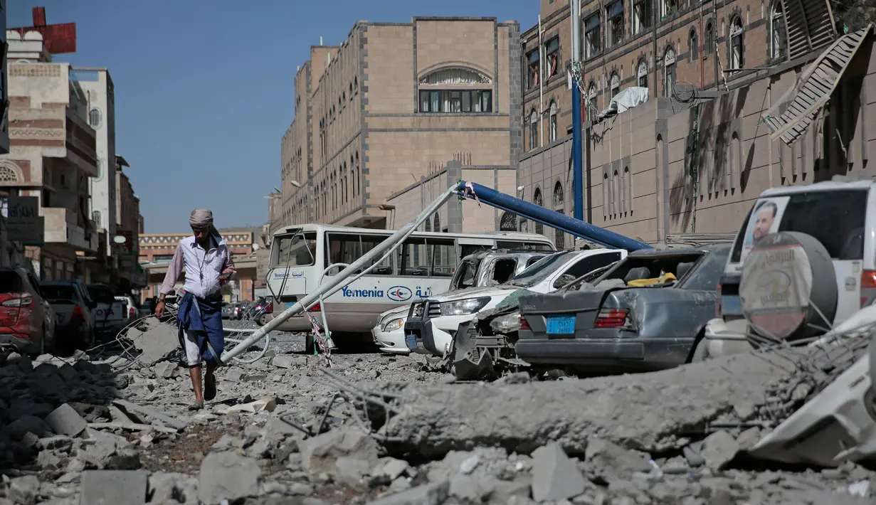 Seorang pria berjalan melewati puing-puing gedung yang runtuh di kompleks kepresidenan, di Sanaa, Yaman (7/5). Akibat serangan ini sedikitnya enam orang tewas dan sekitar 30 orang terluka. (AP Photo/Hani Mohammed)