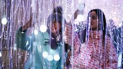 Orang-orang memotret "Anima" karya Elisava, instalasi lebih dari 3.000 benang serat optik, sebagai bagian dari festival Winter Lights di Canary Wharf, di London, Rabu (18/1/2023). Festival ini menerangi Canary Wharf dengan koleksi spektakuler lebih dari 20 instalasi. (AP Photo/Alberto Pezzali)