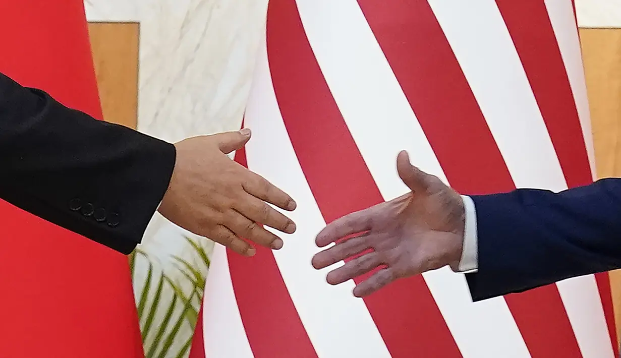 Presiden AS Joe Biden (kanan) dan Presiden China Xi Jinping berjabat tangan sebelum pertemuan mereka di sela-sela pertemuan puncak G20 di Nusa Dua, di Bali, Senin (14/11/2022). Ini merupakan jabat tangan dan tatap muka langsung perdana antara keduanya sejak Biden menjadi Presiden AS dua tahun lalu. (AP/Alex Brandon)