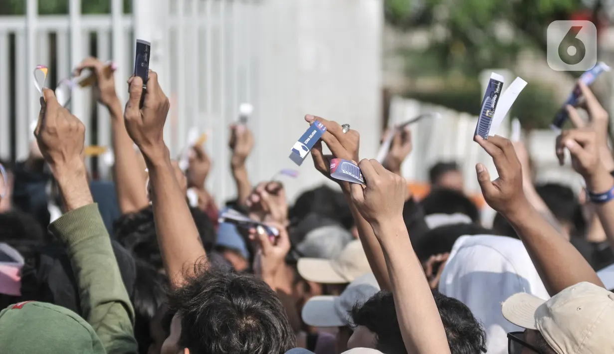 Warga menunjukkan gelang sebagai tanda bukti tiket masuk Grand Launching Jakarta International Stadium (JIS), Papanggo, Jakarta Utara, Minggu (24/7/2022). Grand Launching atau peresmian stadion baru Ibu Kota yang akan dimeriahkan oleh konser band papan atas dan laga persahabatan Persija Jakarta tersebut disambut antusias warga yang terlihat mulai memadati sejak siang tadi. (Liputan6.com/Iqbal S. Nugroho)