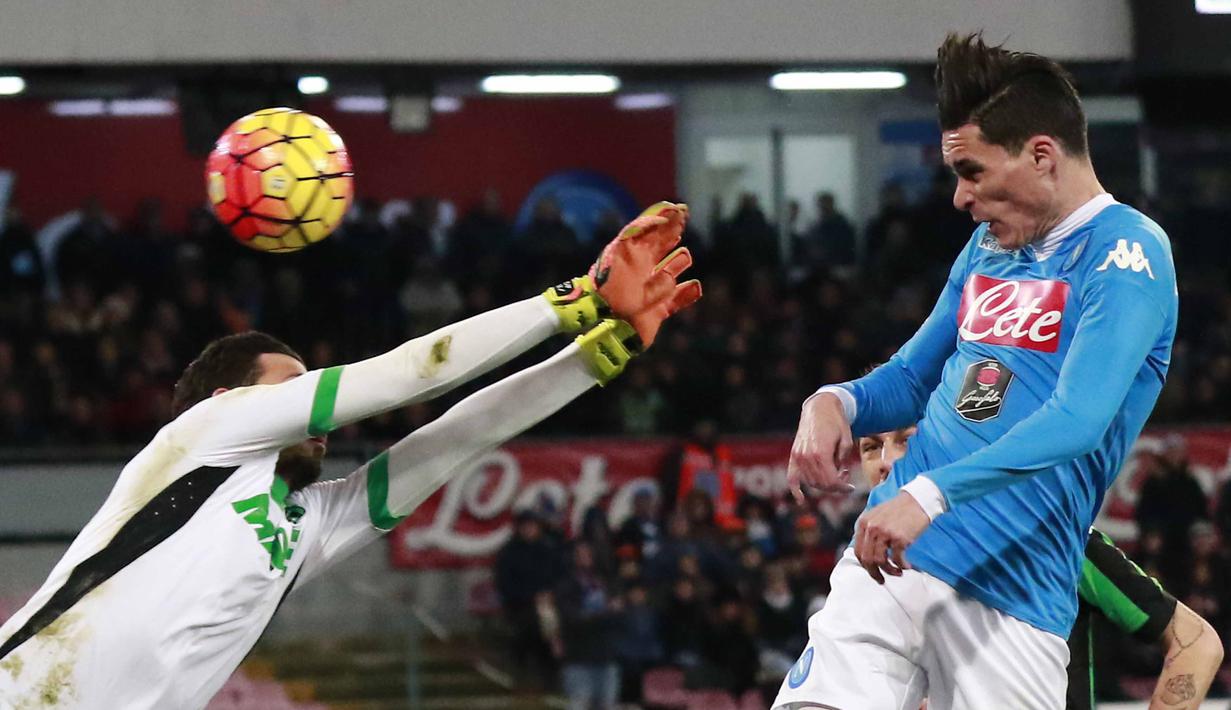 Pemain Napoli, Jose Maria Callejon menyundul bola saat dihalangi kiper Sassuolo, Andrea Consigli (kiri) pada lanjutan Italia Serie A antara Napoli vs Sassuolo di Stadion  San Paolo, Naples, Sabtu (16/1/2016).  (AFP Photo/Carlo Hermann)