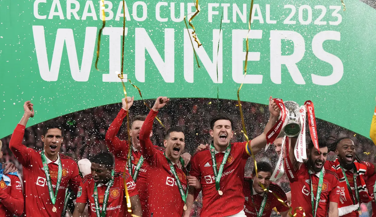 Para pemain Manchester United melakukan perayaan setelah menerima trofi juara Carabao Cup 2022/2023 saat partai final di Stadion Wembley, Senin dini hari WIB (27/2/2023). Manchester United atau MU menang 2-0 atas Newcastle United di Final Carabao Cup 2022/2023. (AP Photo/Alastair Grant)