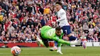 Pemain Tottenham Hotspur Son Heung-min mencetak gol ke gawang Arsenal yang dijaga oleh David Raya pada pertandingan sepak bola Liga Inggris di Emirates Stadium, London, Inggris, Minggu (24/9/2023). Pertandingan berakhir imbang dengan skor 2-2. (AP Photo/David Cliff)