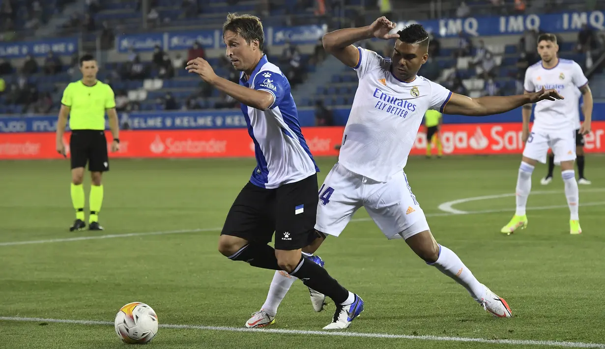 Gelandang Real Madrid Casemiro Real mencoba menghentikan gelandang Deportivo Alaves Tomas Pina pada partai perdana La Liga Spanyol musim 2020/2021 di Estadio de Mendizorroza, Minggu dini hari WIB (15/8/2021). Real Madrid menang telak 4-1. (AP Photo/Alvaro Barrientos)