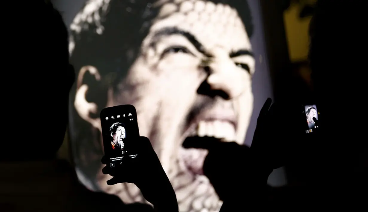 Menggunakan kamera telepon genggam, beberapa pengunjung pantai Copacabana, Rio de Janeiro, Brasil, mengabadikan diri di depan iklan bergambar Luis Suarez, (26/6/2014). (REUTERS/Kai Pfaffenbach) 