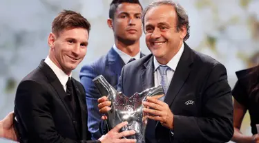 Lionel Messi menerima piala penghargaan sebagai pemain terbaik Eropa 2014-2015 dari Presiden UEFA Michel Platini di Monte Carlo, Kamis (27/8/2015). Pemain Argentina ini menyisihkan Cristiano Ronaldo dan Luis Suarez. (REUTERS/Eric Gaillard)