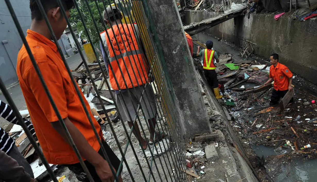 Para pekerja terlihat sedang mengangkat puing-puing bekas penggusuran bangunan liar di kawasan Stasiun Tebet, Jakarta, Selasa (19/8/14). (Liputan6.com/Miftahul Hayat)