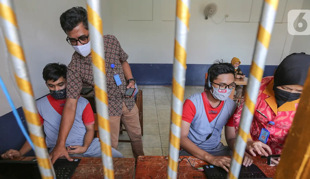 Anak binaan dibantu pegawai lapas anak tengah menyiapkan komunikasi virtual dengan keluarganya di Lembaga Pembinaan Khusus Anak (LPKA) Klas 1 Tangerang, Banten, Sabtu (30/5/2020). Kunjungan fisik diganti dengan komunikasi virtual selama pandemi Covid-19. (Liputan6.com/Fery Pradolo)