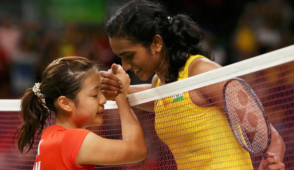 Atlet bulu tangkis India, P.V. Sindhu (kanan) menyalami lawannya dari Jepang Nozomi Okuhara pada semifinal bulu tangkis wanita di Rio de Janeiro, Brasil, (18/8). P.V. Sindhu menang 2 set langsung atas Nozomi Okuhara. (REUTERS/Marcelo del Pozo)