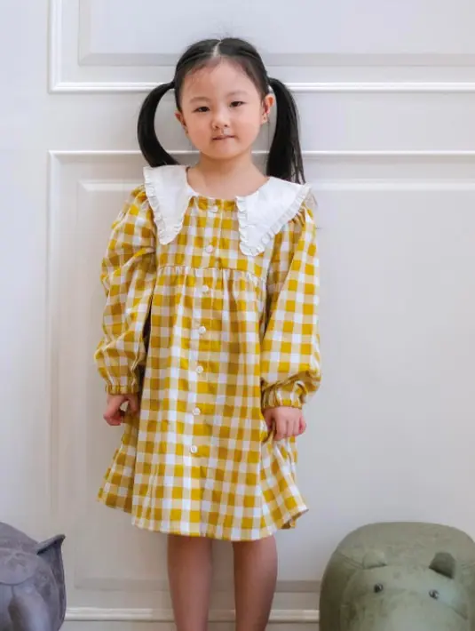 Styling selanjutnya adalah gaya feminin! Dengan dress tartan dari Mourance bersama sepatu sandal polos, OOTD anak nampak makin bergaya. (instagram.com/mourance.id)