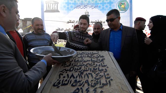 Upacara peletakan batu pertama untuk pembangunan kembali Masjid Agung al-Nuri yang ikonik di Kota Tua Mosul, 16 Desember 2018. Bangunan bersejarah ini hancur tahun lalu dalam pertempuran sengit antara pasukan Irak dengan ISIS. (Zaid AL-OBEIDI/AFP)
