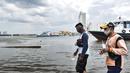 Petugas melintasi kapal yang tidak beroperasi saat banjir rob merendam Pelabuhan Kali Adem, Muara Angke, Jakarta, Kamis (22/10/2020). Banjir akibat air pasang dengan ketinggian mencapai 30 cm tersebut telah merendam kawasan Pelabuhan Kali Adem dan sudah berlangsung selama lima hari. (merdeka.com/Iqb