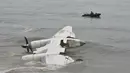 Pasukan keamanan berlayar di lepas pantai Port-Bouet,di dekat lokasi jatuhnya pesawat kargo Antonov yang menewaskan 4 orang warga Moldovan di Abidjan (14/10). Pesawat tersebut jatuh akibat dihantam ombak Pantai Gading. (AFP PHOTO / Sia KAMBOU)
