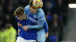 Penyerang Everton, Anthony Gordon berebut bola dengan bek Manchester City, John Stones pada pertandingan lanjutan Liga Inggris di Goodison Park di Liverpool, Inggris, Minggu (27/2/2022). Man City menang tipis atas Everton 1-0. (AP Photo/Jon Super)