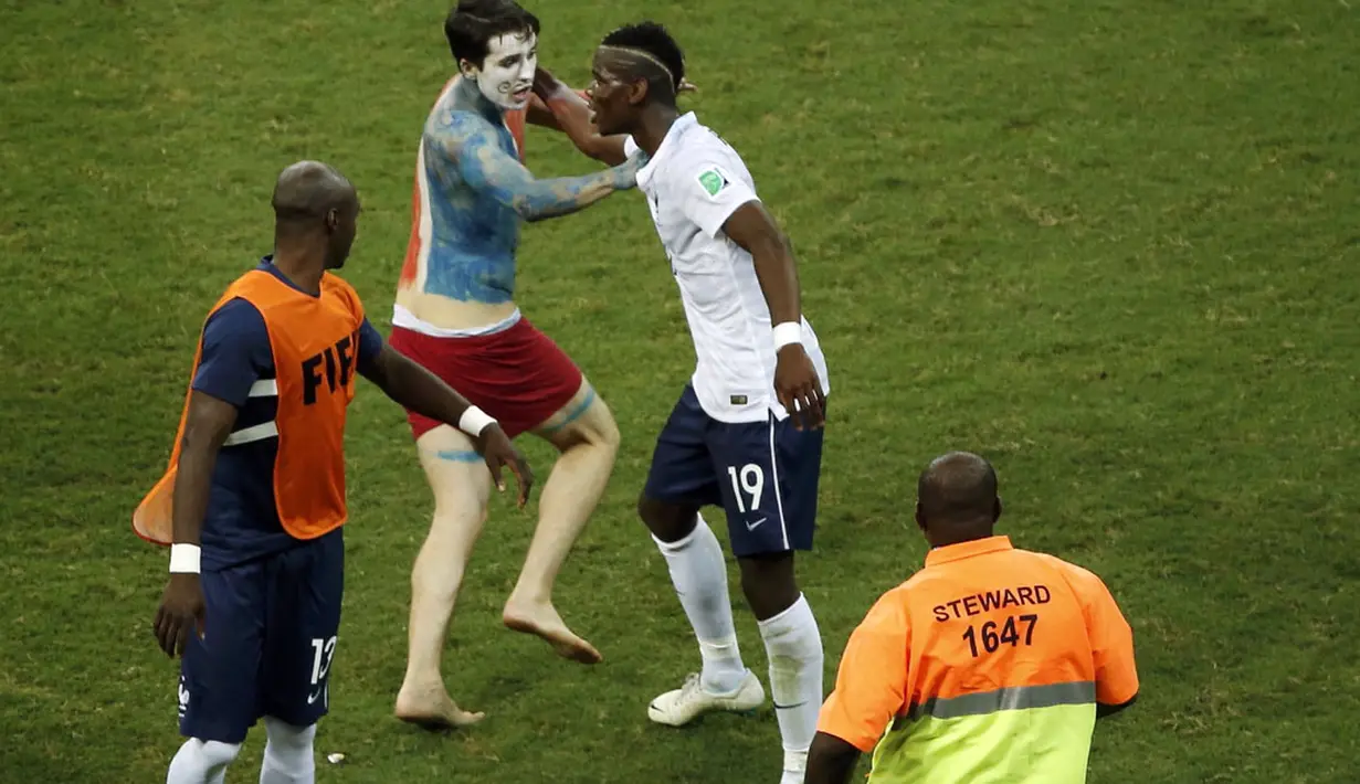 Salah satu suporter Perancis berlari masuk ke lapangan dan menarik Paul Pogba di Stadion Fonte Nova, Salvador, Brasil, (21/6/2014). (REUTERS/Fabrizio Bensch)