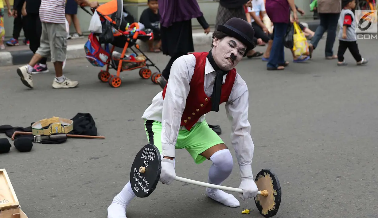 Seniman pantomim tampil menghibur pengunjung car free day di Jakarta, Minggu (1/7). Aksi tersebut dilakukan guna mengumpulkan biaya yang akan digunakan untuk menikah. (Liputan6.com/Immanuel Antonius)