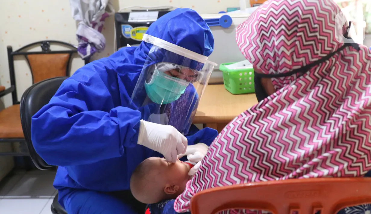 Bidan mengenakan alat pelindung diri (APD) saat melakukan imunisasi kepada bayi di Puskesmas Karawaci Baru, Tangerang, Banten, Rabu (13/5/2020). Pelayanan imunisai sesuai jadwal ini diberikan kepada bayi untuk menambah kekebalan imun tubuh. (Liputan6.com/Angga Yuniar)