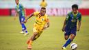 Pemain Sriwijaya FC, Titus Bonai, beradu cepat dengan pemain Gresik United, Samsul Arifin, pada laga Piala Jenderal Sudirman di Stadion Kanjuruhan, Malang, Kamis (19/11/2015). (Bola.com/Vitalis Yogi Trisna)