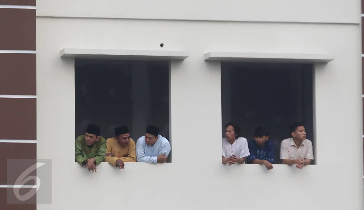 Sejumlah warga menyaksikan prosesi pemakaman jenazah tokoh PBNU KH Hasyim Muzadi di Pondok Pesantren Al Hikam, Beji, Depok, Kamis (16/3). KH Hasyim mengembuskan napas terakhir di Kota Malang sekitar pukul 06.15 WIB. (Liputan6.com/Immanuel Antonius)