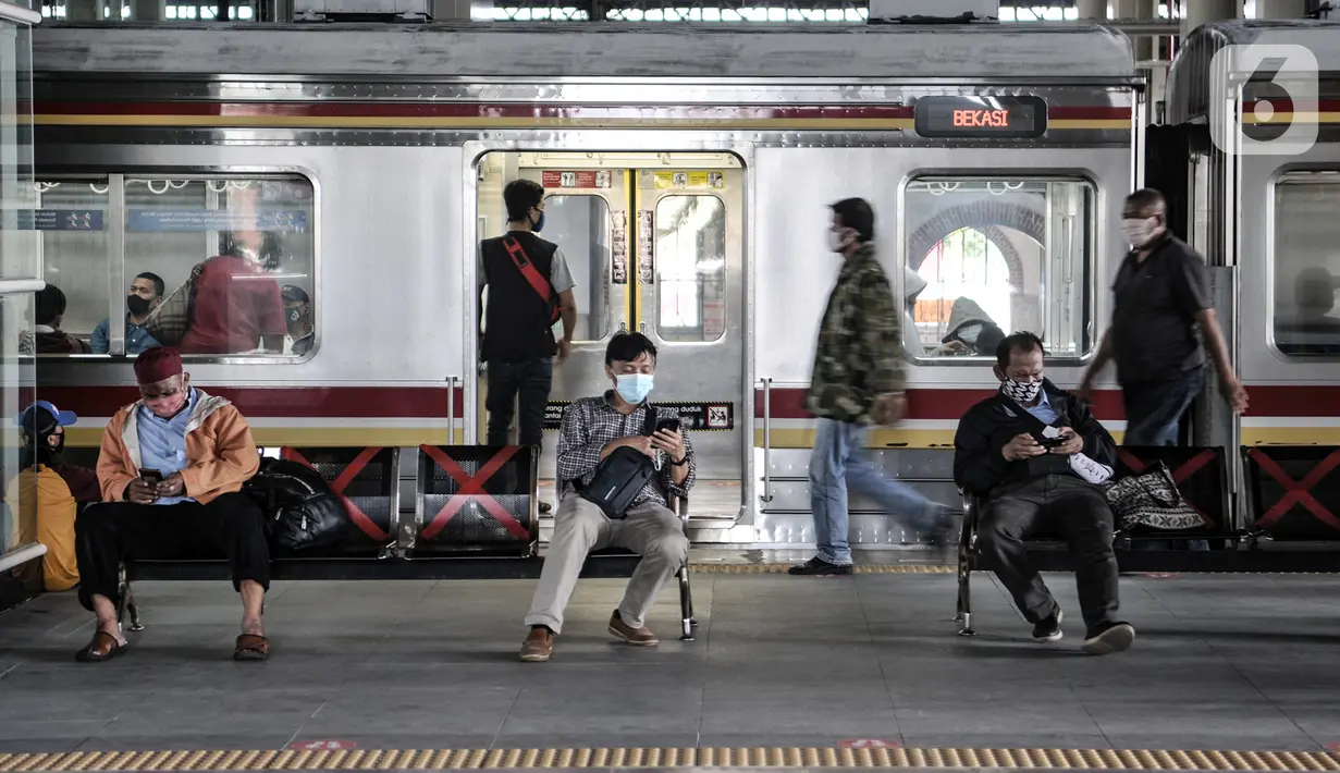 Penumpang Commuter Line menunggu kedatangan kereta di Stasiun Jatinegara, Jakarta, Rabu (16/12/2020). Dirjen Perkeretaapian Kemenhub mengubah level crossing (lintas bawah) menjadi overpass (lintas atas) demi meningkatkan keselamatan penumpang. (merdeka.com/Iqbal S. Nugroho)
