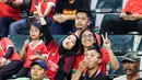 Ditemani rekan prianya, seorang suporter wanita berpose mendukung Timnas Indonesia U-17 saat menghadapi Timnas Panama U-17 pada laga kedua Grup A Piala Dunia U-17 2023 di Stadion Gelora Bung Tomo, Surabaya, Senin (13/11/2023). (Bola.com/Bagaskara Lazuardi)