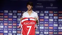 Gelandang Atletico Madrid, Joao Felix tersenyum saat berpose dengan jersey klub barunya selama perkenalan dirinya di Stadion Wanda Metropolitano, Madrid (8/7/2019). Pemain Portugal ini resmi diboyong Atletico seharga 126 juta euro dengan kontrak selama tujuh tahun. (AP Photo/Manu Fernandez)