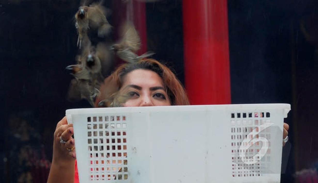 Seorang warga Tionghoa melepaskan sejumlah burung setelah melaksanakan sembahyang Hari Raya Imlek di Vihara Dharma Bakti, Petak Sembilan, Jakarta, Kamis (19/2/2015). (Liputan6.com/Andrian M Tunay)