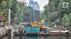 Pekerja dari Dinas Sumber Daya Air (SDA) Provinsi DKI Jakarta menggunakan kendaraan alat berat saat menyelesaikan proyek normalisasi Kali Ciliwung di Jalan Gunung Sahari, Jakarta Pusat, Senin (22/8/2022). Pemprov DKI Jakarta melalui Dinas SDA memastikan program normalisasi Kali Ciliwung terus berjalan dengan prioritas di lokasi aliran utama sungai dan tujuh kelurahan yang merupakan titik rawan banjir. (merdeka.com/Iqbal S. Nugroho)