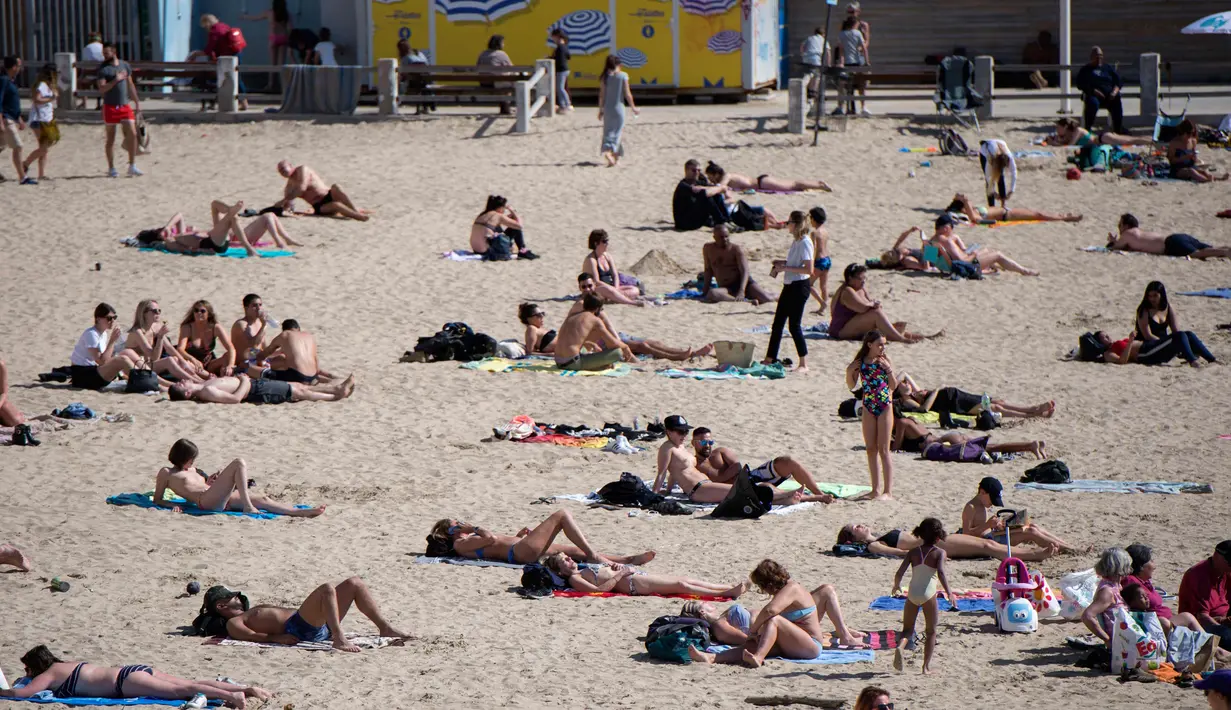 Orang-orang berjemur dan berenang di pantai Catalans (Plage des Catalans) di Marseille, Prancis Selatan, (17/4). Pantai Catalans di Marseille adalah pantai paling populer dan paling dekat dengan Vieux-Port (Old Harbour). (AFP Photo/Bertrand Langlois)