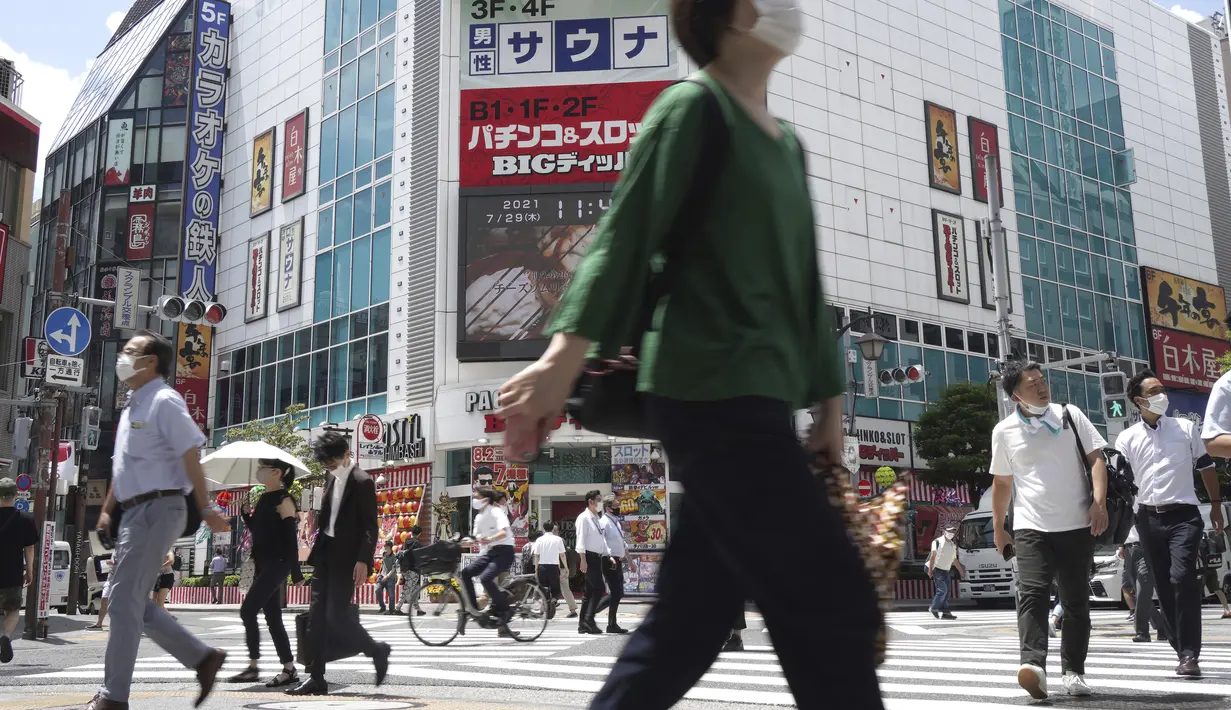 Orang-orang berjalan melintasi persimpangan dekat Stasiun Shimbashi di Tokyo, sehari setelah kasus corona COVID-19 tertinggi ditemukan di kota tuan rumah Olimpiade, Kamis (29/7/2021). (AP/Kntaro Komiya)