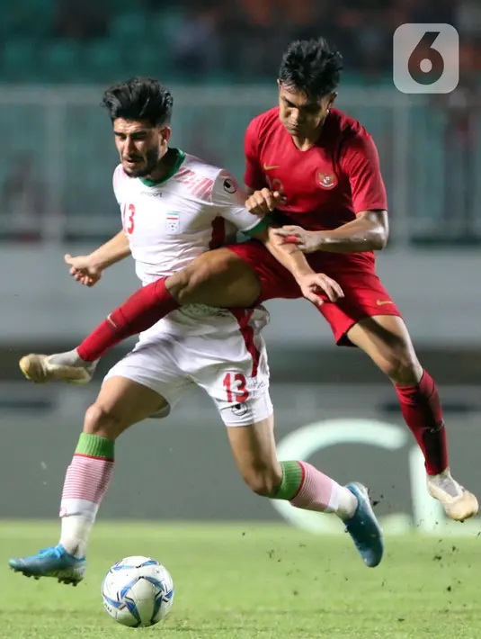 Pemain tengah Timnas Indonesia U-23, Rachmat Irianto (kanan) berebut bola dengan pemain Iran, M Sharifi saat laga persahabatan di Stadion Pakansari, Kab Bogor, Sabtu (16/11/2019). Laga ini uji coba terakhir jelang Sea Games Filipina 2019, Indonesia U-23 unggul 2-1. (Liputan6.com/Helmi Fithriansyah)