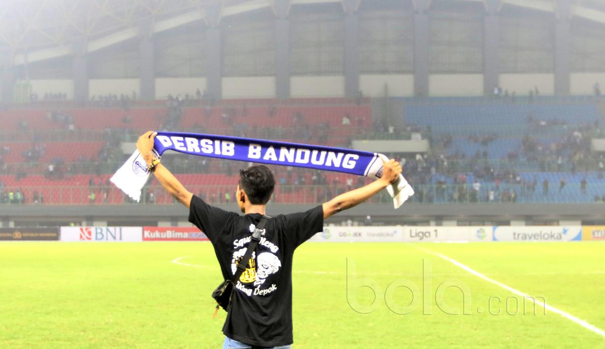Seorang Bobotoh membentangkan syal timnya usai laga Liga 1 2017 antara Bhayangkara FC melawan Persib Bandung di Stadion Patriot, Bekasi, Minggu (4/6/2017). Persib kalah 0-2. (Bola.com/Nicklas Hanoatubun)