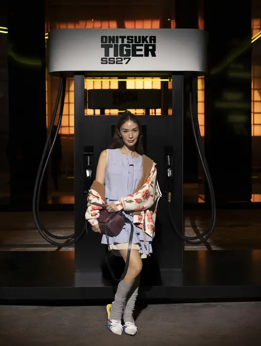 Heart Evangelista terlihat feminin dengan sleeveless lavender berdetail saku dan rok bertumpuk. Dipadu jaket bomber motif bunga berkerah bulu yang disampirkan di bahu, tas marun, kaus kaki tinggi abu-abu, dan flat shoes putih Onitsuka Tiger. [dok. Onitsuka Tiger]