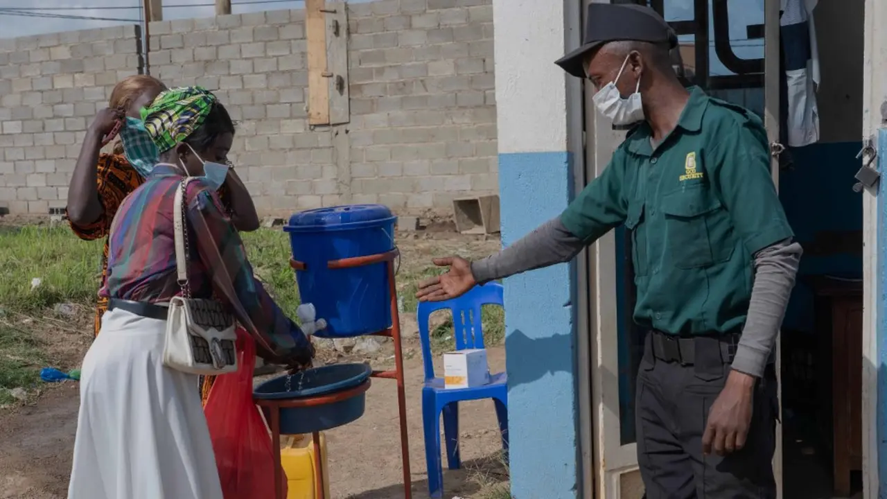 Warga mengenakan masker dan mencuci tangan saat hendak masuk rumah sakit di Bunia, Kongo. (Foto: AP/Dirole Lotsima)