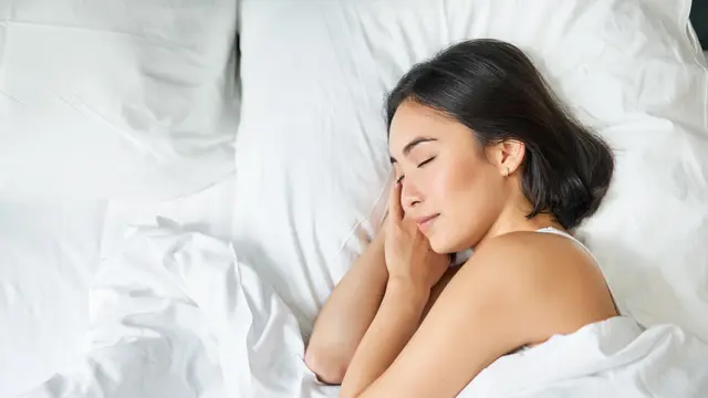 Seorang perempuan tertidur nyenyak di kasurnya (Foto Dok: Freepik/benzoix)