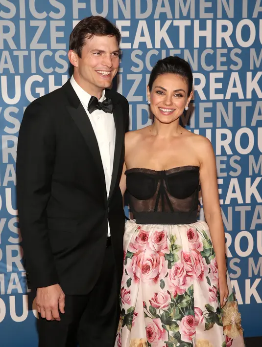 Pasangan selebriti, Ashton Kutcher dan Mila Kunis berpose untuk fotografer di karpet merah Breakthrough Prize Awards di California, 3 Desember 2017. Mila dan Ashton tampak sangat serasi dengan busana yang mereka kenakan. (Jesse Grant/GETTY IMAGES/AFP)