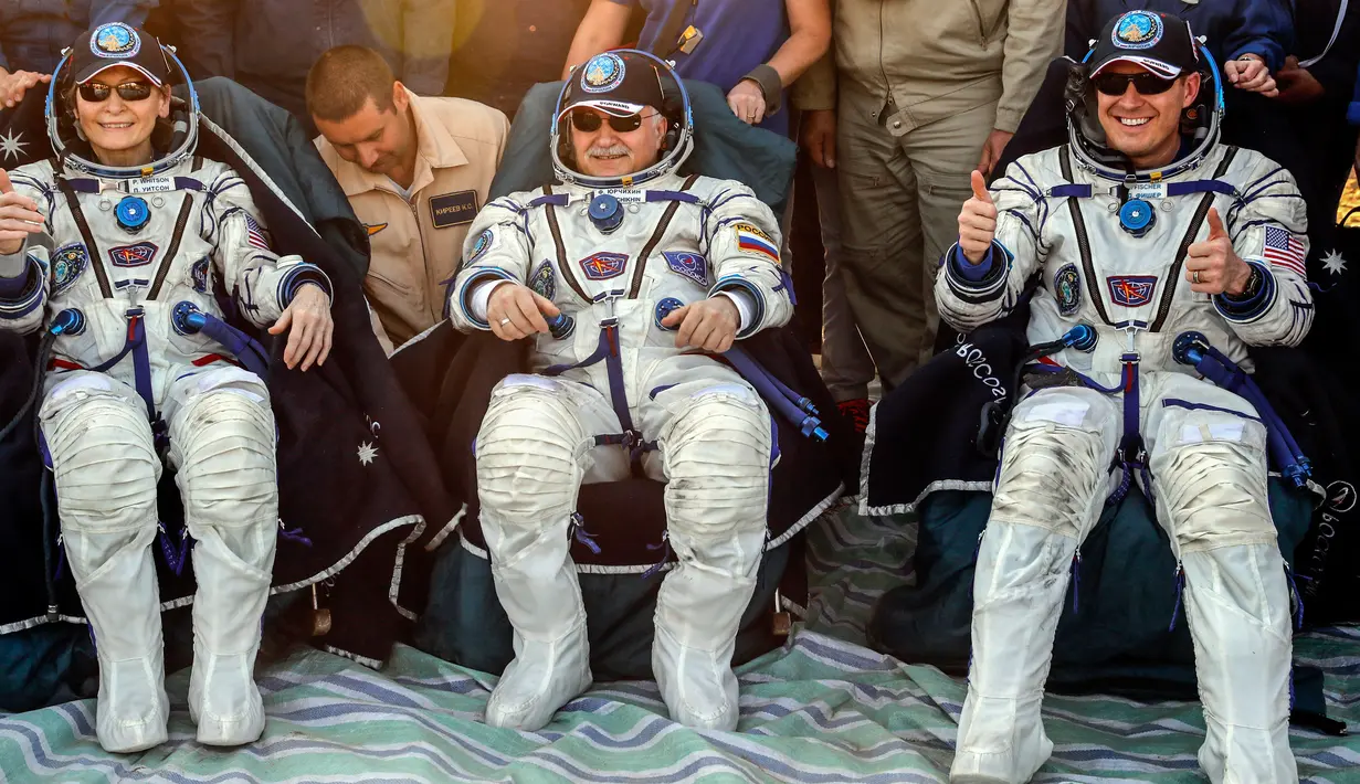 Astronaut AS, Peggy Annette Whitson (kiri) bersama Jack Fisher (kanan) dari NASA dan kosmonaut Rusia, Fyodor Yurchikhin setelah berhasil mendarat di daerah terpencil di luar kota Dzhezkazgan, Kazakhstan, Minggu (3/9). (Sergei Ilnitsky/Pool via AP)