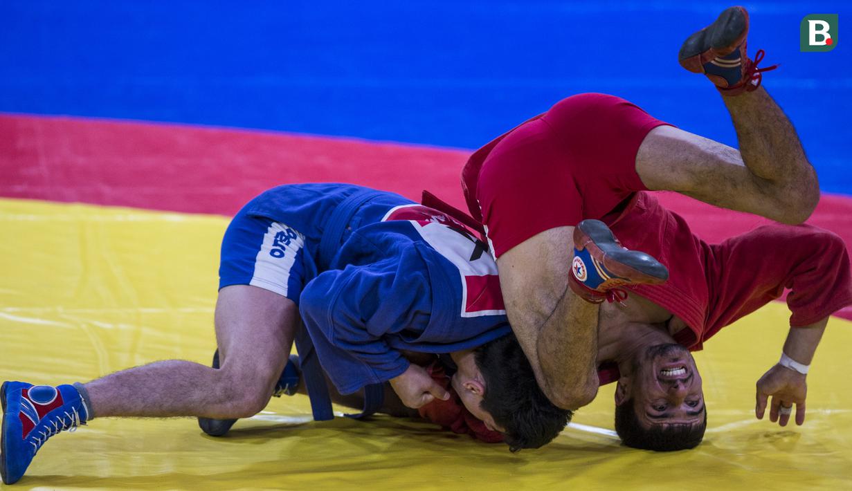 Atlet sambo Uzbekistan, Akhmad Rakhmatilloev, dibanting lawannya atlet sambo Tajikistan, Khasani Dzhomii, pada perebutan tempat ketiga cabang sambo kelas 52 kg Asian Games XVIII di JCC Senayan, Jakarta, Jumat (31/8/2018). (Bola.com/Vitalis Yogi Trisna)