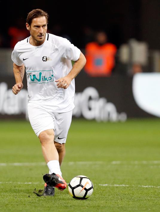 Legenda sepak bola Italia, Francesco Totti mengumpan bola saat mengikuti pertandingan perpisahan Andrea Pirlo, di Stadion Milan San Siro, Italia, (21/5).(AP Photo / Antonio Calanni)