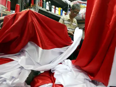 Seorang penjahit mengerjakan pesanan bendera merah putih di Pasar Senen, Jakarta, Selasa (9/8). Jelang peringatan HUT Republik Indonesia ke-72 para penjahit di Pasar Senen mengalami peningkatan pemesanan bendera merah putih. (Liputan6.com/Johan Tallo)