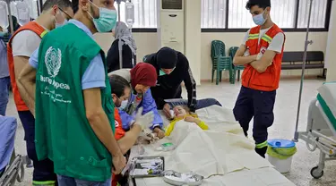 Staf medis merawat seorang pasien anak yang sedang dirawat akibat wabah Kolera di aula masjid yang diubah menjadi rumah sakit lapangan di Kota Bebnine, Distrik Akkar, Lebanon Utara, Rabu (26/10/2022). Awalnya Kementerian Kesehatan Masyarakat Lebanon memberi tahu WHO pada 6 Oktober 2022 tentang dua kasus Kolera yang dikonfirmasi laboratorium dan dilaporkan dari bagian utara negara itu. (AFP/Ibrahim Chalhoub)