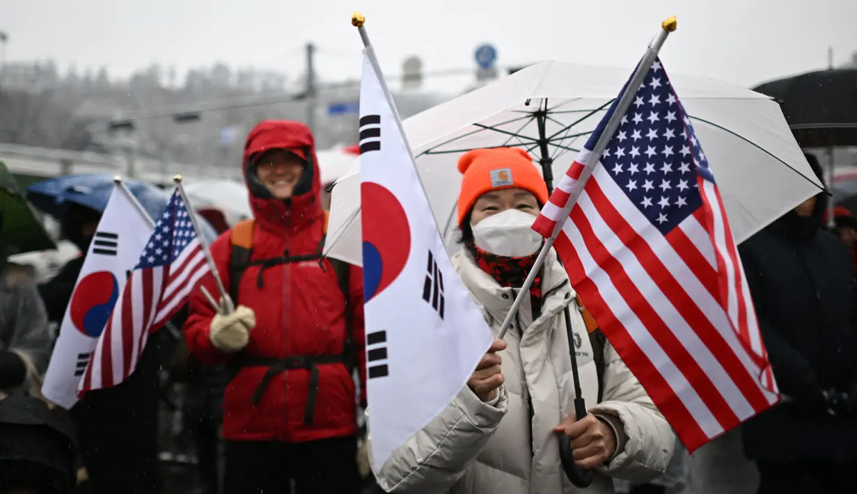 Para pendukung Presiden Korea Selatan yang dimakzulkan, Yoon Suk Yeol, membentangkan plakat bertuliskan "Kami akan berjuang untuk Presiden Yoon Suk Yeol". (Philip FONG/AFP)