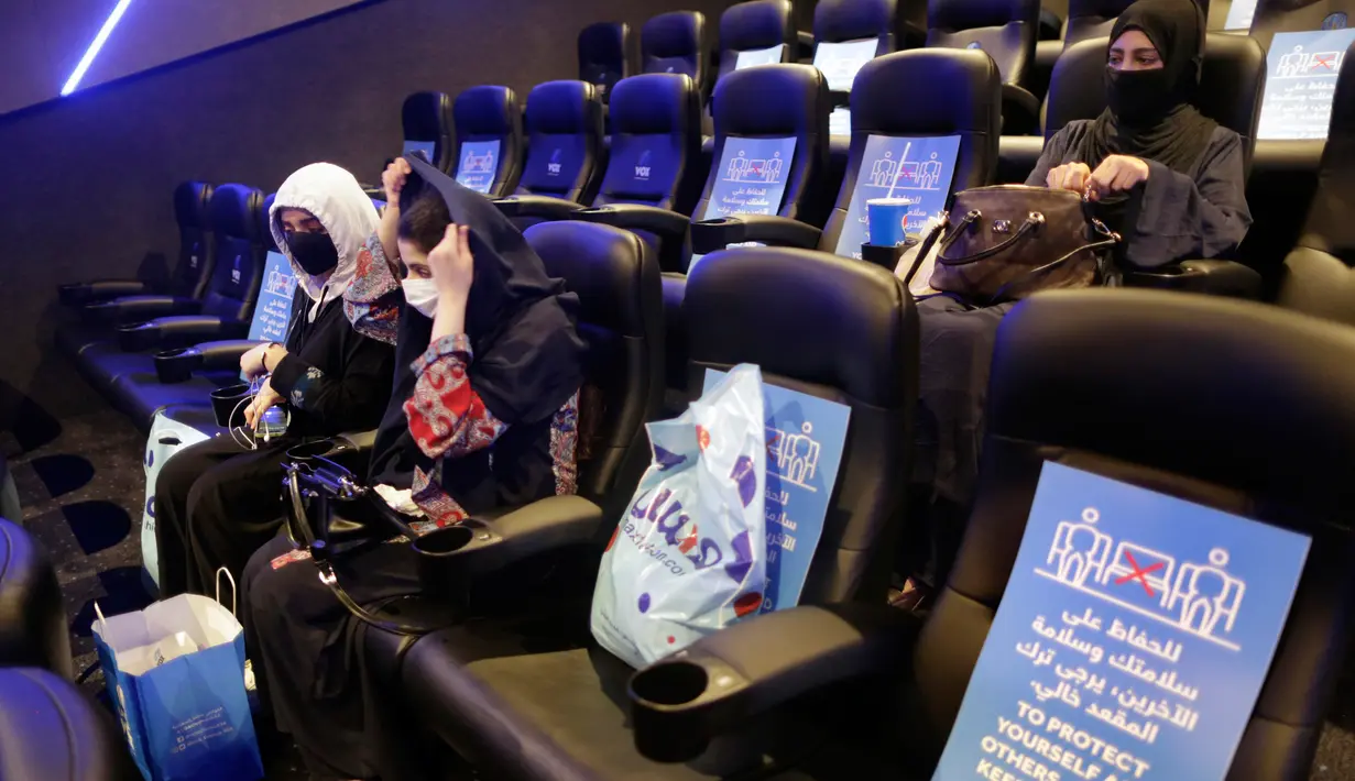 Perempuan Saudi mengenakan masker untuk mencegah penyebaran Covid-19 bersiap menyaksikan film di aula Bioskop VOX di Jiddah, Arab Saudi (26/6/2020). Pemerintah Arab Saudi membuka kembali bioskop setelah melonggarkan lockdown Covid-19. (AP Photo/Amr Nabil)