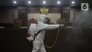 Petugas Palang Merah Indonesia saat melakukan penyemprotan cairan disinfektan di salah satu ruang sidang Pengadilan Negeri Jakarta Pusat, Rabu (18/3/2020). Penyemprotan cairan disinfektan untuk mencegah penyebaran virus corona COVID-19. (Liputan6.com/Helmi Fithriansyah)