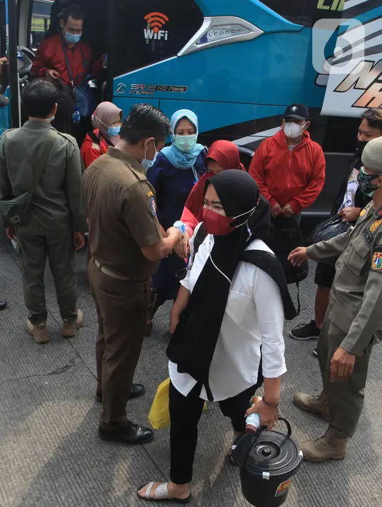 Pemudik turun dari bus Antar Kota Antar Provinsi (AKAP) setibanya di Terminal bus Kalideres, Jakarta Barat, Senin (17/5/2021). Arus balik pemudik mulai terlihat di sejumlah terminal di Jakarta, salah satunya di Terminal Kalideres. (Liputan6.com/Angga Yuniar)