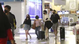 Penumpang melintas di aera cek in pesawat terbang di terminal 3, Bandara Soetta, Tangerang, Banten, Rabu (15/12/2021). Pemerintah mengeluarkan aturan perjalanan terbaru selama periode libur Natal tahun 2021 dan perayaan tahun baru 2022 semakin ketat. (Liputan6.com/Angga Yuniar)